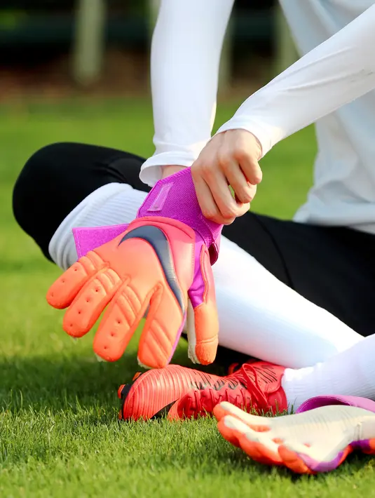 Kiper timnas China, Zhao Lina memakai sarung tangan sebelum mengikuti latihan di Shanghai (15/5). Wanita 26 tahun ini berharap dirinya dapat membantu meningkatkan kompetisi sepak bola wanita di China. (AFP Photo/China Out)