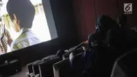 Anak-anak menyaksikan film di Indiskop atau Bioskop Rakyat di dalam Pasar Jaya Teluk Gong, Jakarta Utara, Rabu (3/6/2019). Teater satu untuk menampung warga dewasa dengan harga tiket 15 ribu rupiah dan teater dua untuk anak-anak dengan harga tiket 5 ribu rupiah. (Liputan6.com/Faizal Fanani)