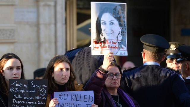 Pengunjuk rasa memegang foto mendiang jurnalis Malta, Daphne Caruana Galizia, yang tewas dibunuh saat menginvestigasi dugaan korupsi pemerintah (AFP PHOTO)