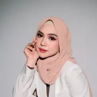 Ada dua konsep yang diusung pada pemotretan kali ini. Pertama, dia tampil simple memakai setelan formal warna putih yang dipadukan hijab warna krem. Penampilannya disempurnakan dengan pulasan makeup flawless nuansa pink. [@@askar_photography]