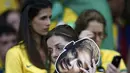 Seorang fans perempuan yang memegang topeng wajah Neymar tak bisa menahan kekecewaannya setelah Brasil dibantai Jerman dengan skor 1-7, Selasa (8/7/14). (REUTERS/Marcos Brindicci)
