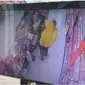 Seorang ibu menggendong bayi saat menjalankan aksi pencurian di sebuah minimarket (Arfandi/Liputan6.com)