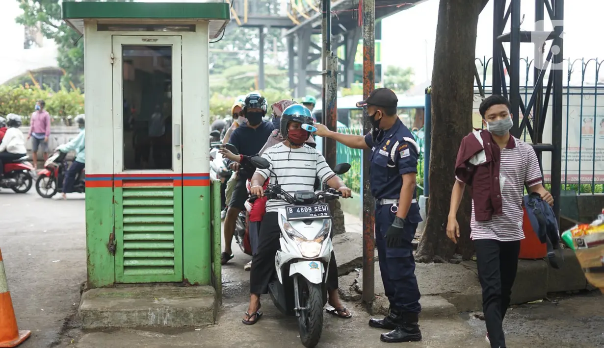 Peugas mengukur suhu pengunjung Pasar Minggu, Jakarta, Kamis (2/7/2020). Pemprov DKI memutuskan untuk mengembalikan operasional seluruh pasar seperti sedia kala dengan memperpanjang jam buka pasar serta menghapus sistem operasional ganjil genap. (Liputan6.com/Immanuel Antonius)