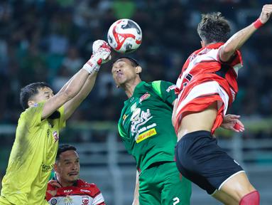 Kiper Madura United, Diky Indriyana, berusaha menghalau bola saat melawan Persebaya Surabaya pada laga BRI Super League di Stadion Gelora Bung Tomo, Surabaya, Jumat (17/04/2026). (Bola.com/M Iqbal Ichsan)