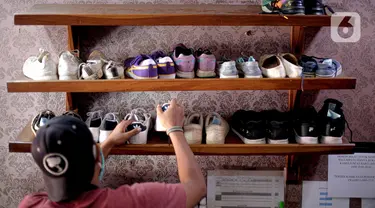 Kru mengambil sepatu untuk dibersihkan di Soul Sepatu di kawasan Rawamangun, Jakarta, Senin (9/11/2020). Jasa pencucian sepatu mengalami peningkatan permintaan pasca sebesar 50 persen pasca pemerintah menerapkan PSBB masa transisi di DKI Jakarta. (Liputan6.com/Faizal Fanani)