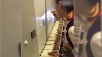 Seorang pramugari tengah makan makanan sisa penumpang (shanghaiist.com)