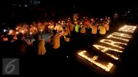 Puluhan karyawan Artha Graha Peduli menyalakan lilin saat menggelar Earth Hours di kawasan SCBD Jakarta, Sabtu (25/3). Kegiatan ini mendukung kampanye perubahan iklim dan pencegahan pemanasan global dengan pemadaman listrik. (Liputan6.com/Fery Pradolo)