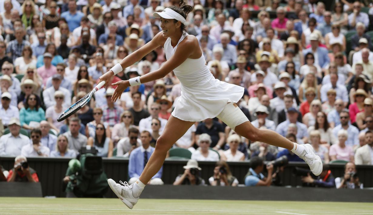 Aksi Garbine Muguruza mengembalikan bola saat melawan Magdalena Rybarikova pada laga semifinal tunggal putri Wimbledon 2017 di London, (13/7/2017). (AP/Kirsty Wigglesworth)