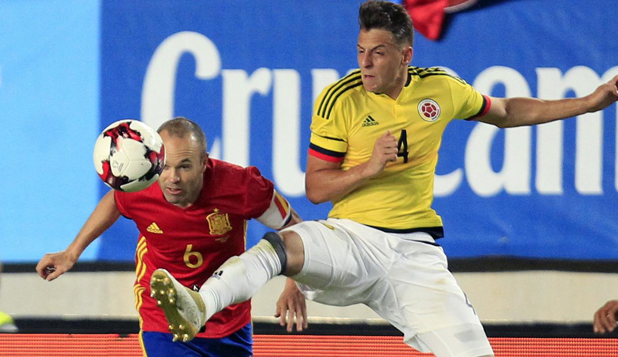Pemain Spanyol, Andres Iniesta (kiri) berduel dengan pemain Kolombia, Santiago Arias pada Laga Persahabatan di Estadio Nueva Condomina, Murcia, Spanyol (7/6/2017). (AP/Alberto Saiz)