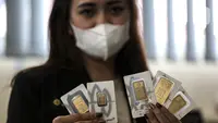 Pramuniaga menunjukkan emas batangan PT Aneka Tambang (Antam) Tbk di sebuah gerai emas, Jakarta, Senin (18/1/2021). Pada hari ini, harga emas Antam turun menjadi Rp 944 ribu per gram. (Liputan6.com/Johan Tallo)
