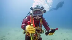 Seorang penyelam menunjukkan botol anggur yang disimpan di dasar Laut Mediterania di Saint-Mandrier, Prancis selatan, 15 Mei 2017. Sejumlah penyelam Prancis melakukan percobaan proses pematangan anggur di dalam air selama setahun. (Boris HORVAT/AFP)