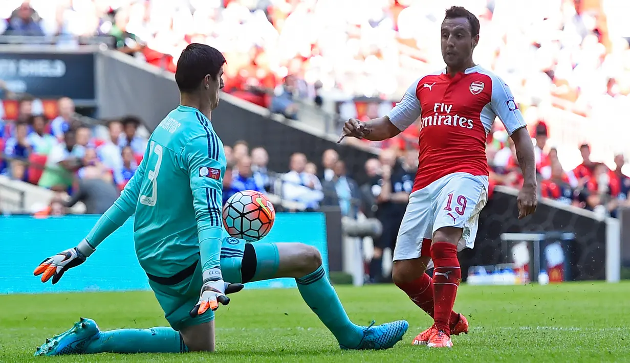 Kiper Chelsea, Thibaut Courtois (kiri) berusaha menangkap bola tendangan gelandang Arsenal, Santi Cazorla pada pertandingan FA Community Shield di Wembley Stadium, Minggu (2/8/2015). Arsenal menang atas Chelsea dengan skor 1-0. (Reuters/Dylan Martinez)
