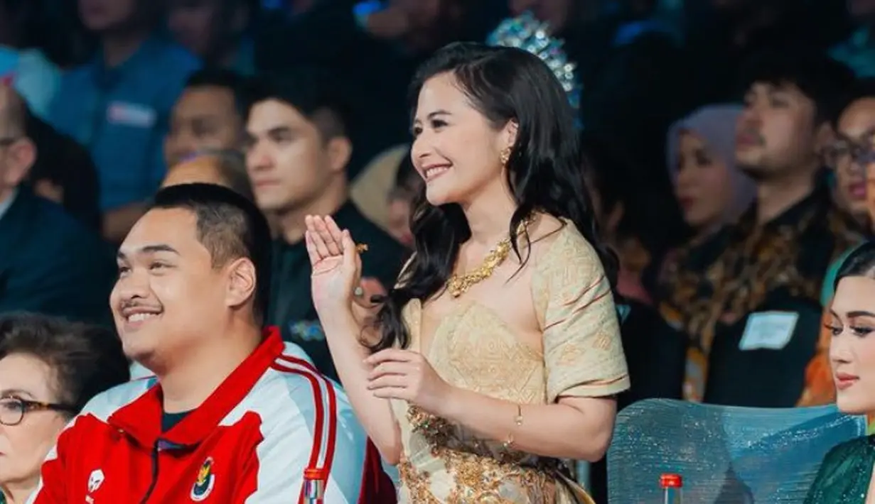 Wajahnya pun dihias dengan makeup flawles glam mengaplikasikan lipstik coklat dan blush on tipis. Mengenakan eyeshadow abu-abu shimmer. [@prillylatuconsina96]