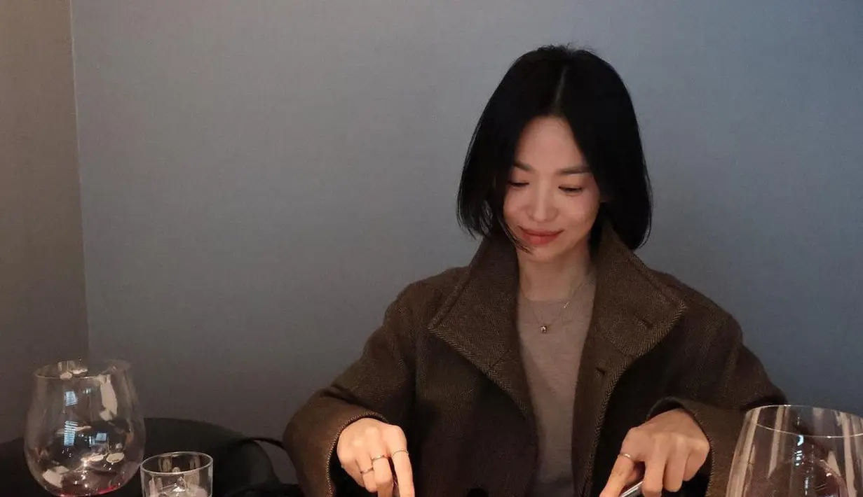 Song Hye Kyo kenakan knit long sleeve cokelat muda berlapis long coat cokelat tua sebagai outfit dinner. Hanya dilengkapi dengan beberapa aksesori minimalis [@kyo1122]