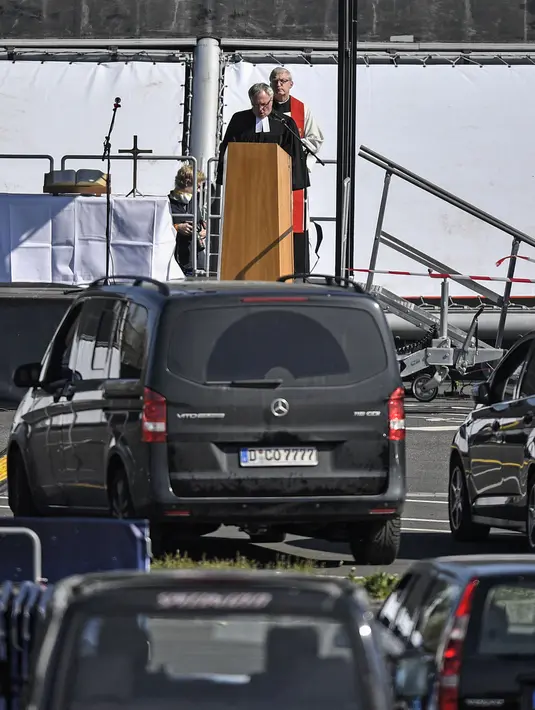 Pastor Frank Heidkamp dan Evangelis Heinrich Fuchs saat kebaktian Jumat Agung di sebuah bioskop drive-in di Duesseldorf, Jerman, Jumat (10/4/2020). Kebaktian drive-in dilakukan setelah Jerman menutup semua tempat ibadah untuk mencegah penyebaran virus corona COVID-19. (AP Photo/Martin Meissner)