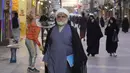 Seorang ulama Syiah berjalan di jalan di kota suci Najaf, Irak, 23 November 2021. Sekolah-sekolah agama di Irak kembali dibuka setelah lebih dari dua tahun di tengah pandemi COVID-19. (Qassem al-KAABI/AFP)