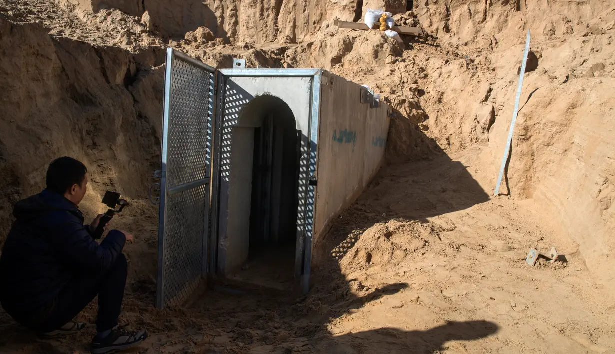 Seorang wartawan di perbatasan Israel dengan Gaza memotret pembukaan sebuah terowongan yang mengarah dari Gaza ke Israel dekat Kibbutz selatan Kissufim, Israel, Kamis (18/1). (Jack Guez/Pool via AP)