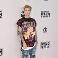 Busana yang dikenakan Justin Bieber kurang pantas dikenakan untuk ajang musik bergengsi American Music Awards. Ia terlihat kurang berkelas dalam kaos kebesaran dan celana jeans robek. (AFP/Bintang.com)