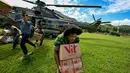 Keempat kabupaten tersebut adalah Bener Meriah, Aceh Tengah, Gayo Lues, dan Aceh Tamiang. Tampak dalam foto, warga membawa bantuan yang didistribusikan oleh personel TNI AU di wilayah terdampak banjir di Kabupaten Bener Meriah, Provinsi Aceh, pada Kamis 4 Desember 2025. (CHAIDEER MAHYUDDIN/AFP)