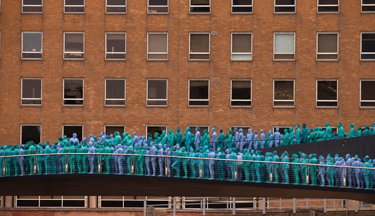 Ribuan orang dengan tubuh tanpa busana saat menjadi model sebuah seni berjudul "Sea of Hull" karya Spencer Tunick asal Amerika Serikat di pusat Kota Hull, Inggris, Sabtu (9/7). (AFP Photo/Jon Super)