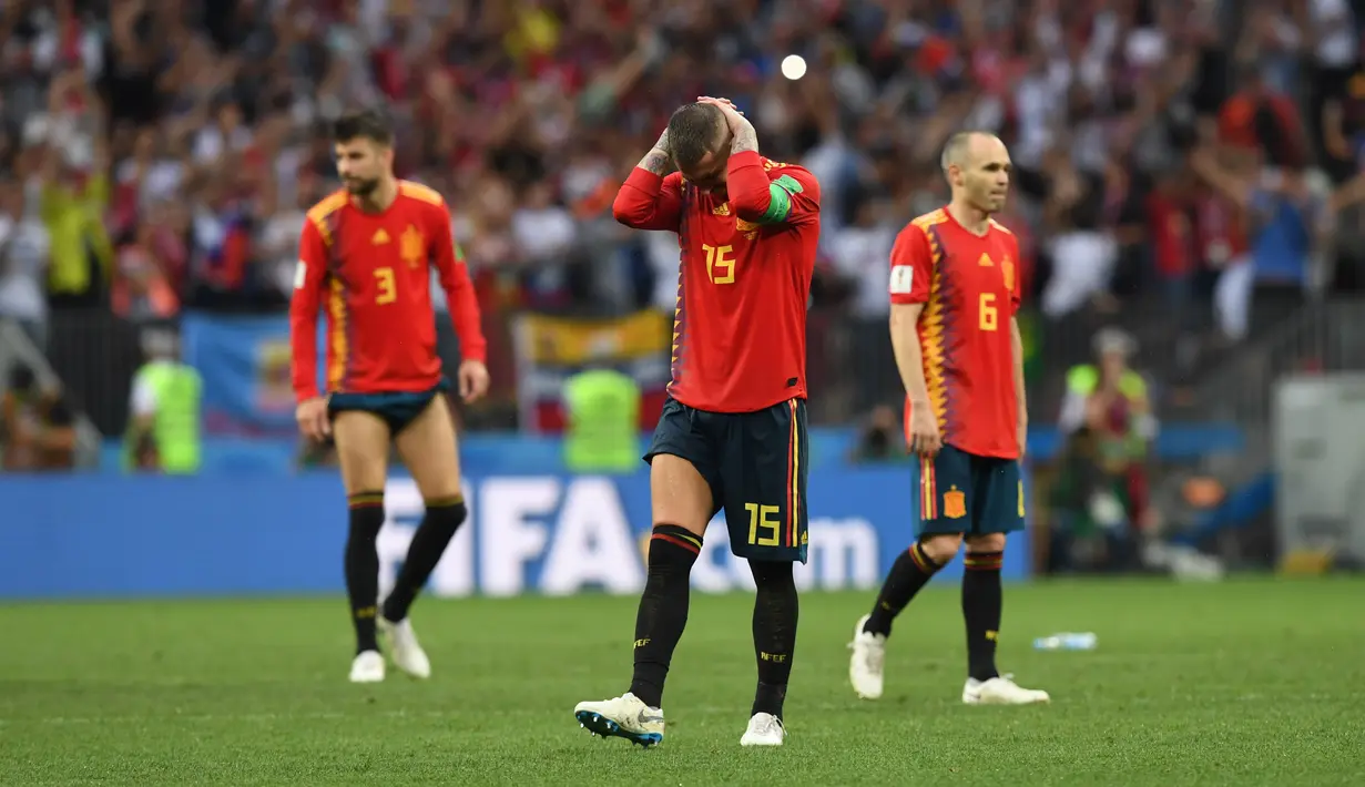Sergio Ramos (tengah) menutup wajahnya usai kalah dari Rusia pada laga 16 besar Piala Dunia 2018 di Luzhniki Stadium, Moskow, Rusia, (1/7/2018). Spanyol kalah adu penalti 3-4. (AFP/Francisco Leong)