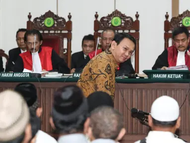 Basuki Tjahaja Purnama (Ahok) tersenyum saat akan duduk di kursi terdakwa untuk menjalani sidang keempat kasus dugaan penistaan agama di Gedung Auditorium Kementerian Pertanian, Jakarta, Selasa (3/1). (Liputan6.com/Dharma Wijayanto/Pool)