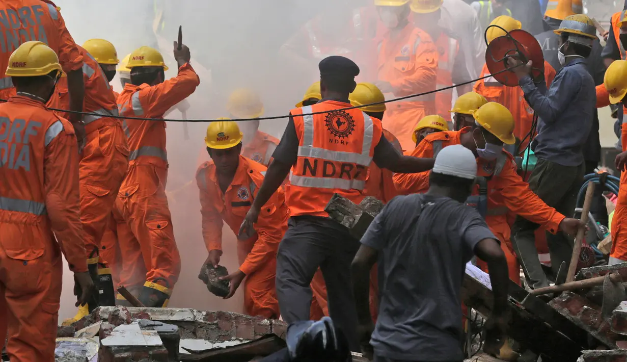 Petugas penyelamat berusaha mencari korban yang tertimbun akibat runtuhnya bangunan di Mumbai, India (31/8). Laporan lokal mengatakan hunian berlantai lima di Mumbai, India ambruk pada Kamis pagi waktu setempat. (AP Photo / Rafiq Maqbool)