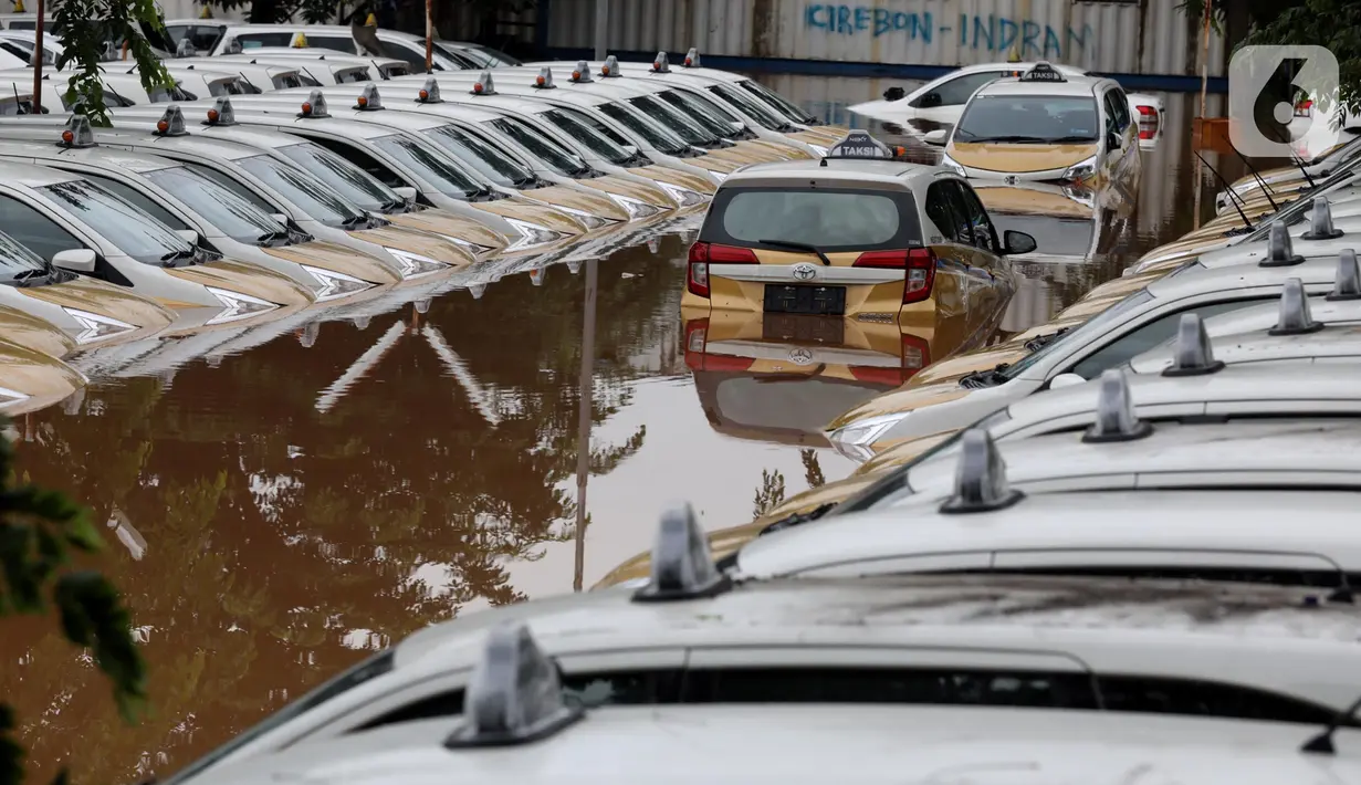 Kondisi dan suasana Pool Taksi Express di kawasan Tanah Kusir yang terendam banjir, Jakarta, Rabu (1/1/2020). Banjir akibat hujan deras yang mengguyur Jakarta dan sekitarnya sejak Selasa sore (31/12/2019) menyebabkan ratusan armada taksi terendam. (Liputan6.com/Johan Tallo)