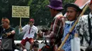 Pengunjuk rasa membawa karton bertuliskan tuntutan mereka saat menggelar aksi mogok dan unjuk rasa di depan gedung DPR/MPR, Jakarta, Selasa (15/9). Para guru honorer itu menuntut Pemerintah mengangkat mereka menjadi PNS. (Liputan6.com/Johan Tallo)