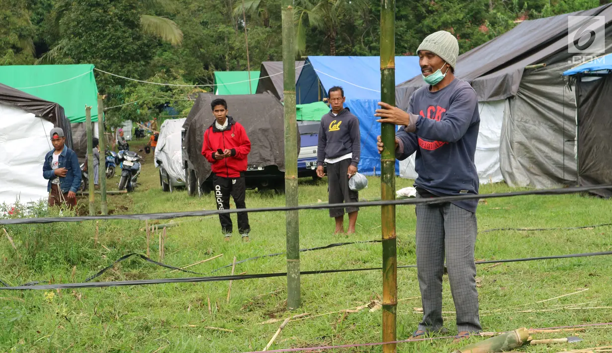 Warga membangun kamp pengungsian Gunung Agung di lahan milik dinas pertanian, Karangasem, Bali, Senin (27/11). Status Gunung Agung yang naik dari siaga ke awas, membuat warga diminta mengungsi dari radius 8 hingga 10 kilometer. (Liputan6.com/Andi Jatmiko)