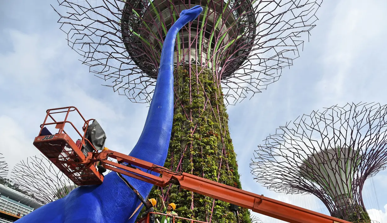 Petugas merekatkan patung dinosaurus di Gardens by the Bay, Singapura, Senin (28/2). Rencananya akan dipamerkan sebanyak 11 dinosaurus beraneka warna untuk merayakan Festival Anak di Singapura. (AFP PHOTO / Roslan RAHMAN)