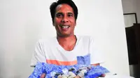 Asisten pelatih Arema, I Made Pasek Wijaya, menunjukkan oleh-oleh batu dari Martapura. (Bola.com/Kevin Setiawan)