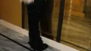 Kylie Jenner tiba menggunakan gaun strapless beludru hitam Schiaparelli SS23, berhiaskan kepala singa berukuran aslinya. [@schiaparelli].