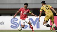 Gelandang Semen Padang, Irsyad Maulana, berusaha melewati bek Mitra Kukar, Roni Fatahilah, pada laga Piala Presiden 2019 di Stadion Patriot, Bekasi, Kamis (14/3). Padang menang 2-0 atas Mitra. (Bola.com/Yoppy Renato)
