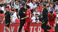 Penyerang Liverpool Mohamed Salah (kanan) meninggalkan lapangan karena cedera dalam pertandingan final Piala FA menghadapi Chelsea di Stadion Wembley, London, 14 Mei 2022. Salah kemungkinan absen saat The Reds melawan Southampton pada pekan ke-37 Liga Inggris, Rabu, 18 Mei. (Ben Stansall / AFP)