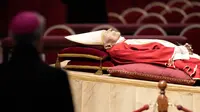 Jenazah mendiang Paus Emeritus Benediktus XVI disemayamkan di Basilika Santo Petrus, Vatikan, Senin (2/1/2023). Benediktus XVI, teolog Jerman yang akan dikenang sebagai paus pertama dalam 600 tahun yang mengundurkan diri, telah meninggal pada 31 Desember 2022 di usia 95 tahun. (AP Photo/Andrew Medichini)