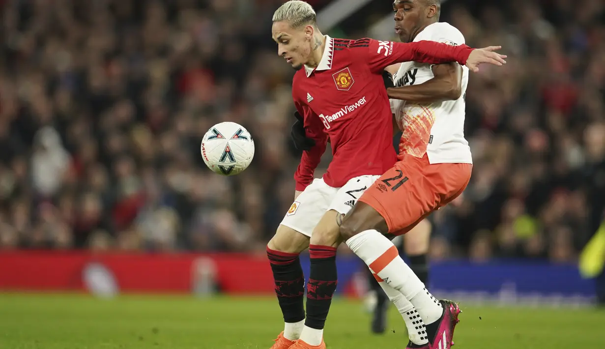 Bek West Ham Angelo Ogbonna berebut bola dengan penyerang Manchester United atau MU Antony pada putaran kelima Piala FA di Old Trafford, Kamis (2/3/2023) dinihari WIB. Skuad Setan Merah menyamakan kedudukan berkat gol bunuh diri Nayef Aguerd lalu dua gol pada menit akhir melalui aksi Alejandro Garnacho dan Fred. (AP Photo/Dave Thompson)