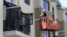 Pekerja memeriksa kerusakan balkon di lantai 4 dari sebuah apartemen yang runtuh, di California, AS, 16 Juni 2015. Enam orang mahasiswa yang berada di balkon itu dikabarkan terjatuh dan tewas. (REUTERS/Elia Nouvelage)