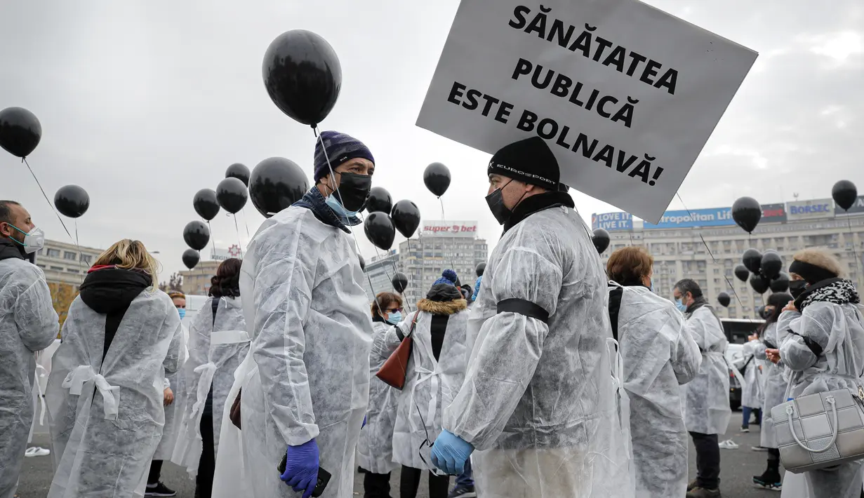 Para petugas medis yang mengenakan masker memegang balon hitam di Bucharest, Rumania, Selasa (17/11/2020). Aksi tersebut untuk mengenang pasien COVID-19 yang tewas dalam kebakaran di instalasi gawat darurat rumah sakit di Piatra Neamt, Rumania pada 14 November 2020 lalu. (AP Photo/Vadim Ghirda)