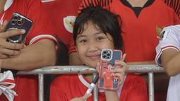 Suporter cilik menunjukkan Handphone bergambar Rafael Struick saat menyaksikan secara langsung pertandingan Timnas Indonesia vs Jepang pada laga Grup C putaran ketiga Kualifikasi Piala Dunia 2026 Zona Asia di Stadion Utama Gelora Bung Karno, Jakarta, Jumat (15/11/2024). (Bola.com.M Iqbal Ichsan)