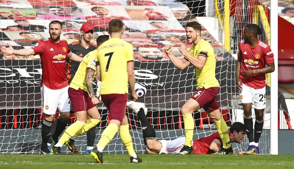 Pemain Burnley James Tarkowski (tengah) melakukan selebrasi usai mencetak gol ke gawang Manchester United pada pertandingan Liga Inggris di Stadion Old Trafford, Manchester, Inggris, Minggu (18/4/2021). Manchester United menang 3-1. (Gareth Copley/Pool via AP)