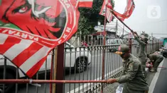 Petugas Satuan Polisi Pamong Praja (Satpol PP) DKI Jakarta menertibkan alat peraga partai politik berbentuk bendera di kawasan Jalan Raya Bogor, Jakarta, Rabu (26/7/2023). Menjelang Pemilu 2024, pemerintah setempat menertibkan sejumlah bendera dan atribut partai politik yang pemasangannya melanggar aturan terutama di sepanjang jalan protokol serta merusak keindahan kota. (Liputan6.com/Faizal Fanani)