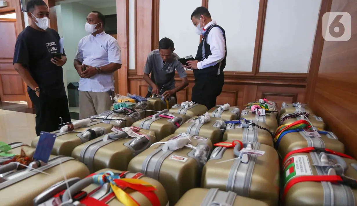 Petugas sedang merapikan koper petugas PPIH di asrama haji Pondok Gede, Jakarta, Selasa (31/5/2022). Petugas  PPIH (Petugas Panitia Penyelenggara Ibadah Haji) sebanyak di  828 orang di berangkatkan pada Rabu (1/6/2022) yang di bagi daerah kerja ke Jeddah, Madinah dan Mekkah. (Liputan6.com/Herman Zakharia)