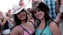 Dua wanita cantik berpose menggunakan topi koboi saat menghadiri Festival musik Country Stagecoach di Empire Polo Club di Indio, California, 29 April 2016. (AFP PHOTO/Jason Kempin)