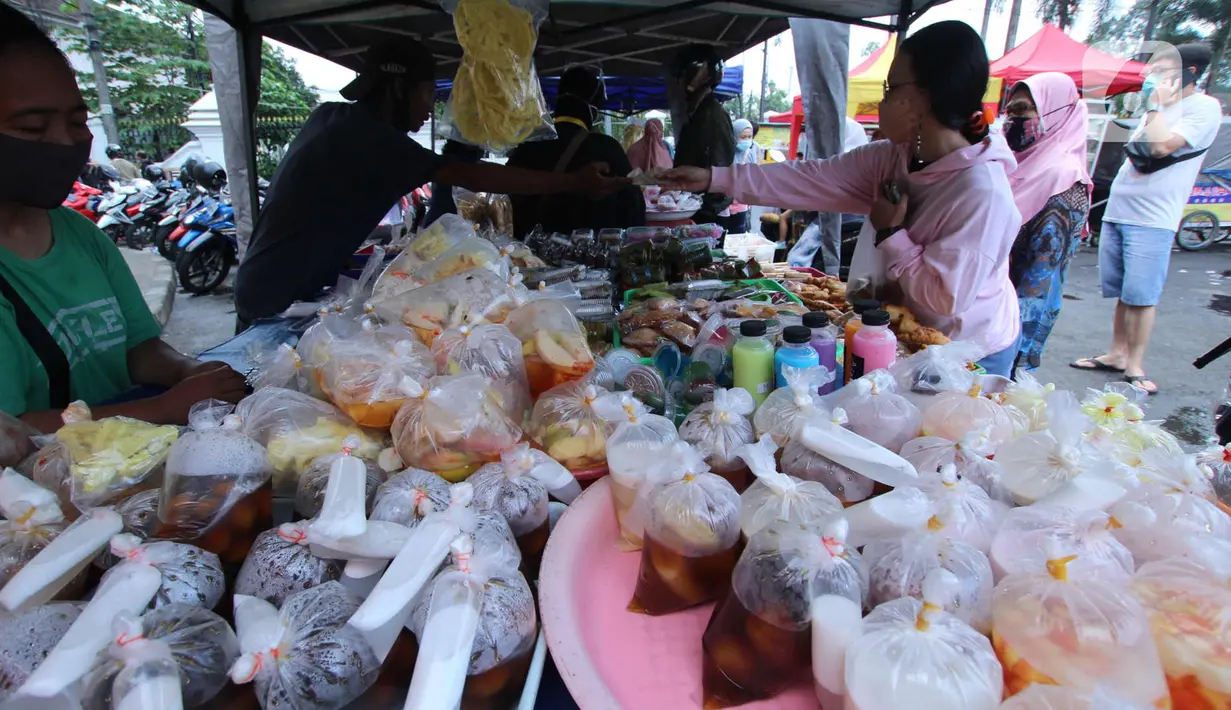 Penjual melayani pembeli makanan untuk berbuka puasa (takjil) di kawasan Pasar Lama, Kota Tangerang, Selasa (20/4/2021). Bulan Ramadhan, membuat sejumlah pedagang takjil musiman bermunculan dan menawarkan aneka makanan dan minuman untuk umat Islam yang menjalankan puasa. (Liputan6.com/Angga Yuniar)