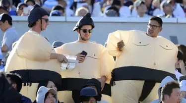Tiga orang pria mengenakan kostum sumo bersiap menyaksikan pertandingan Rugby World Cup Pool C antara Argentina dan Amerika Serikat di Kota Kumagaya, Jepang (9/10/2019).  Rugby World Cup diselenggarakan dari 20 September hingga 2 November 2019. (AP Photo/Eugene Hoshiko)