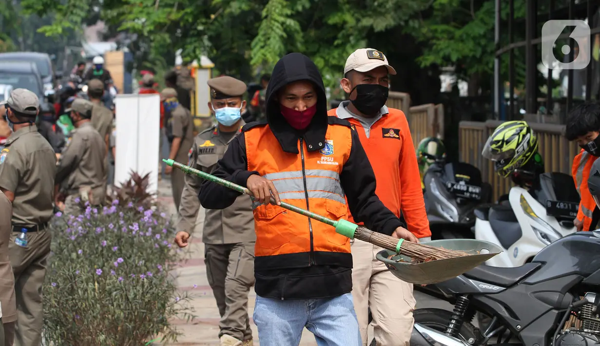 Warga pelanggar PSBB dihukum menyapu saat terjaring razia masker di Jalan Tanjung Duren Raya, Jakarta, Jumat (11/9/2020). Petugas Satpol PP gencar melakukan razia masker menyusul kasus COVID-19 di DKI Jakarta yang terus meningkat. (merdeka.com/Imam Buhori)