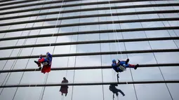 Tokoh superhero Captain America dan Superman membersihkan kaca jendela kamar di rumah sakit anak-anak di Guadalupe, Meksiko, 30 April 2019. Mereka bergelantungan di luar jendela dengan mengenakan kostum superhero untuk menghibur anak- anak yang sedang sakit. (REUTERS/Daniel Becerril)