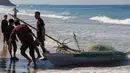 Nelayan Palestina menarik perahu mereka di pantai di Deir el-Balah, di Jalur Gaza Tengah pada 30 November 2023. (Mahmud Hams/AFP)