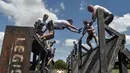 Peserta lomba berusaha melewati rintangan saat mengikuti "Legion Run" di Roma, Italia, Sabtu (13/4). Peserta harus melewati rintangan seperti dari lumpur, es dan kawat berduri dengan jarak tempuh 5 kilometer. (AFP PHOTO / Andreas SOLARO)